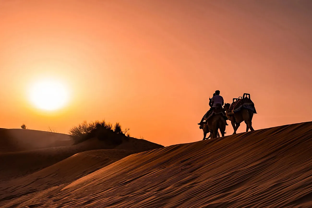 Couple watching sunset over red dunes